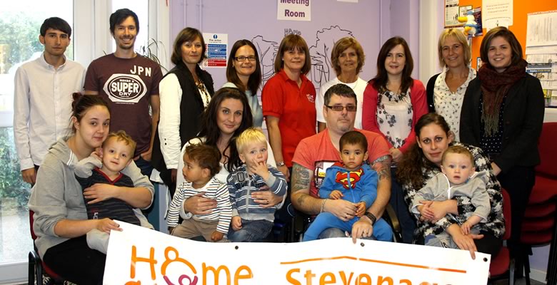 Group photograph of the Daymedia and Home-Start teams, plus some of the parents and children that the charity supports